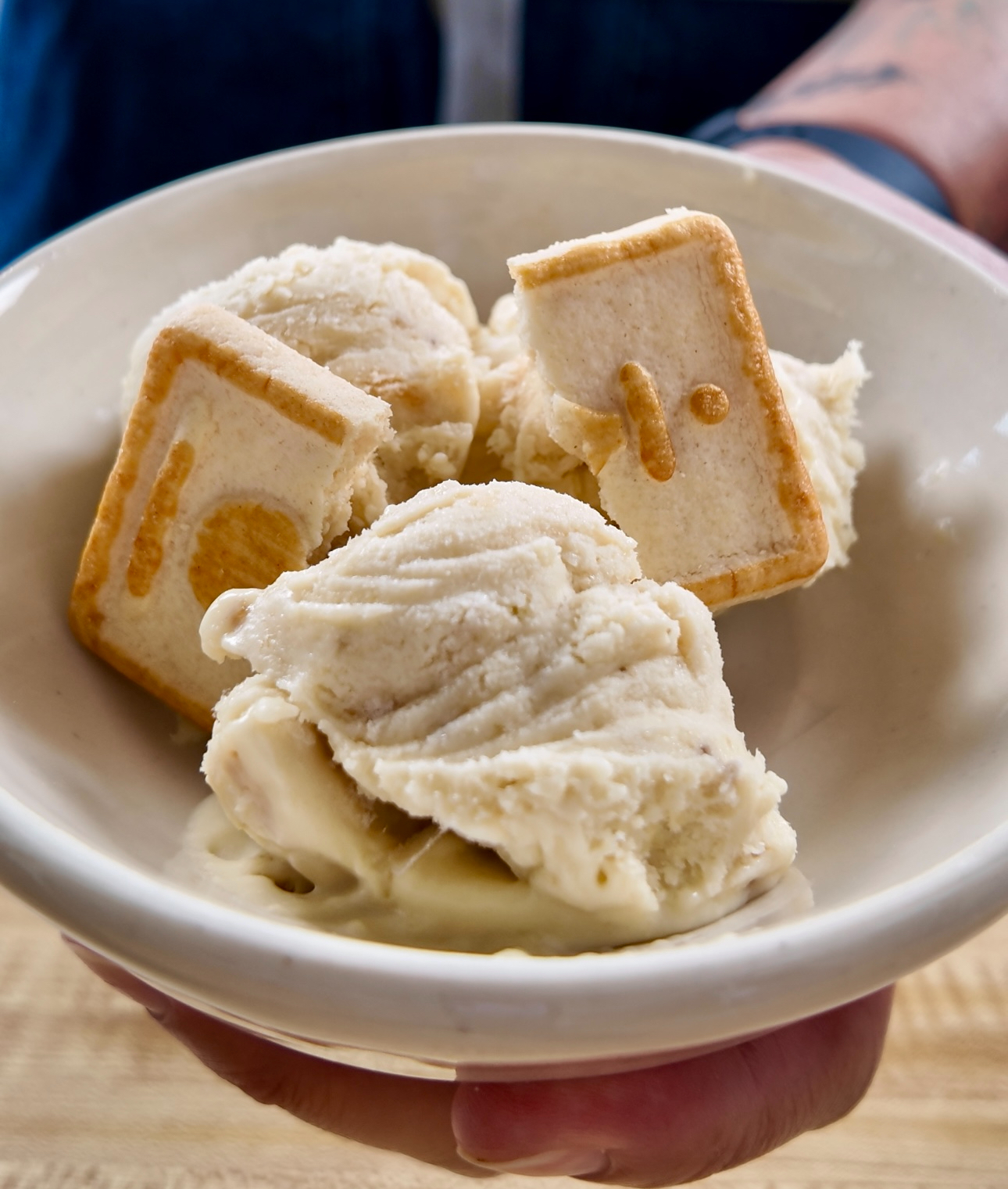 creamy banana pudding cheesecake ice cream in a white bowl with Pepperidge Farm Chessman Cookies