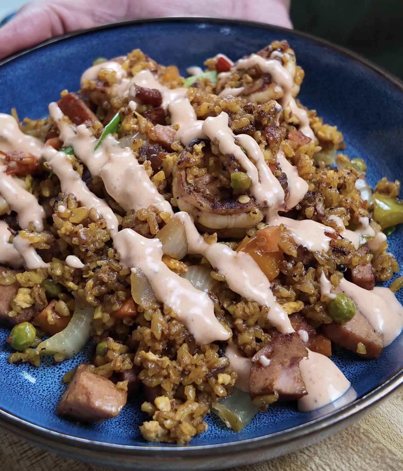 jerk shrimp fried rice in a blue bowl with yum yum sauce