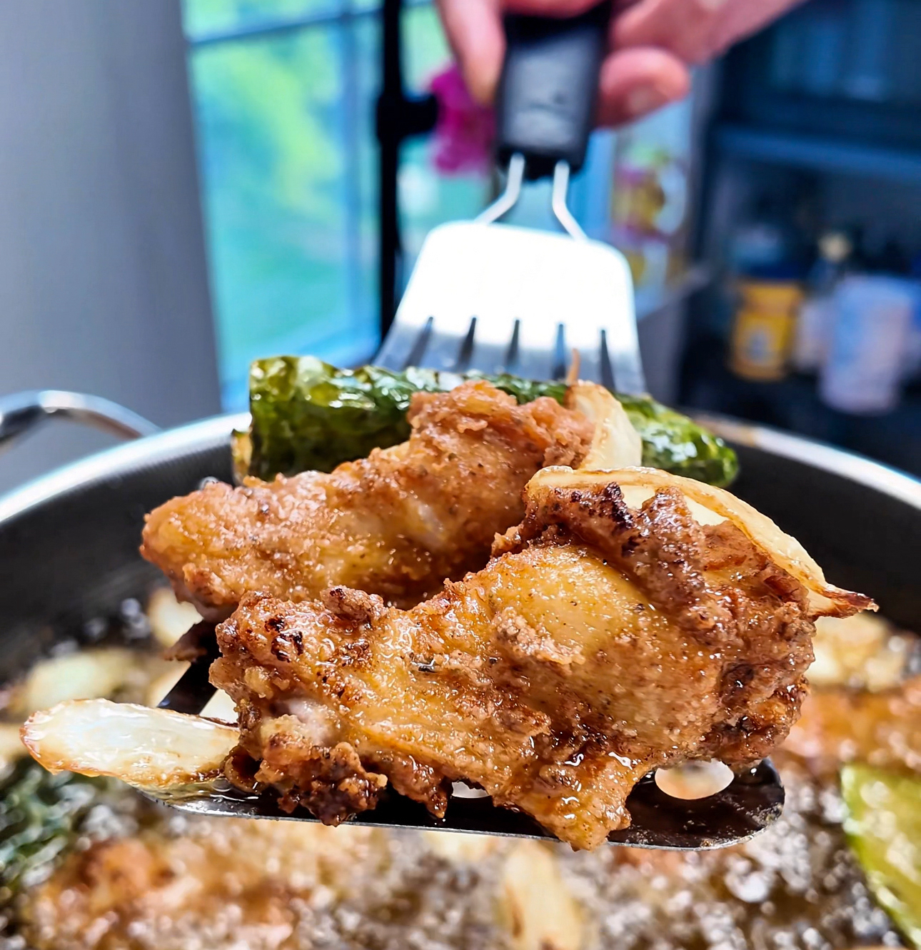 Crispy fried chicken with jalapenos and onions coming straight out of hot oil.