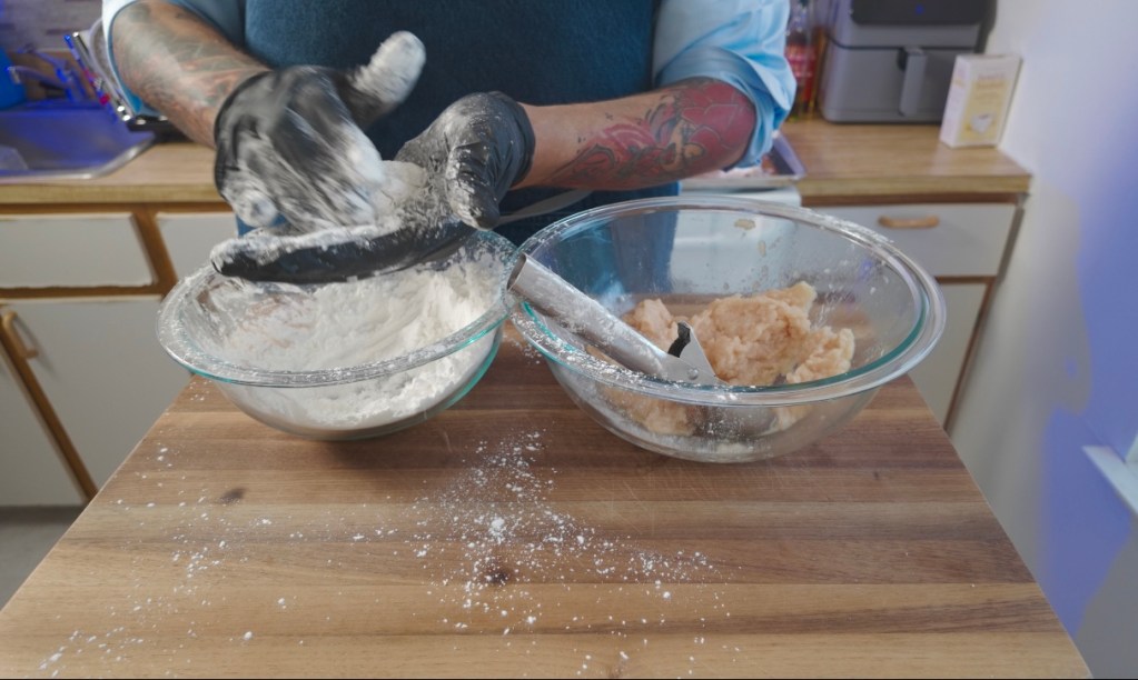 chicken nuggets being formed in cornstarch