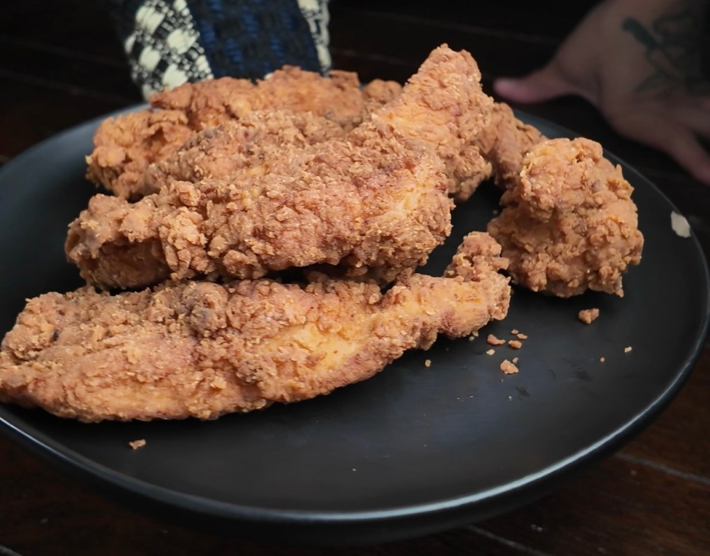 crispy chicken strips on a black plate